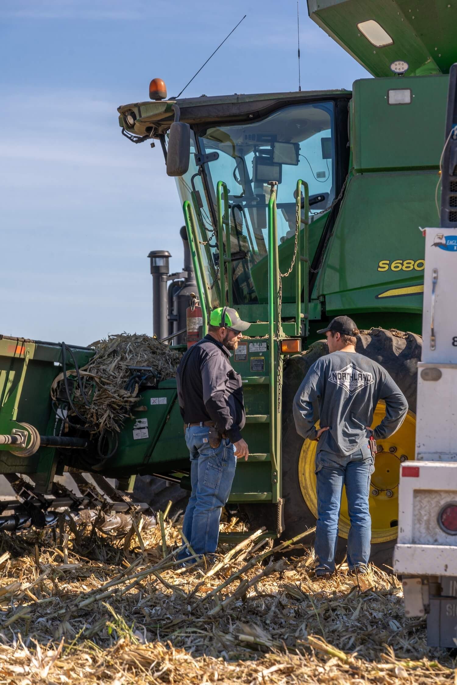 two men talking by combine